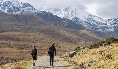 two walkers heading for snow capped carrauntoohil